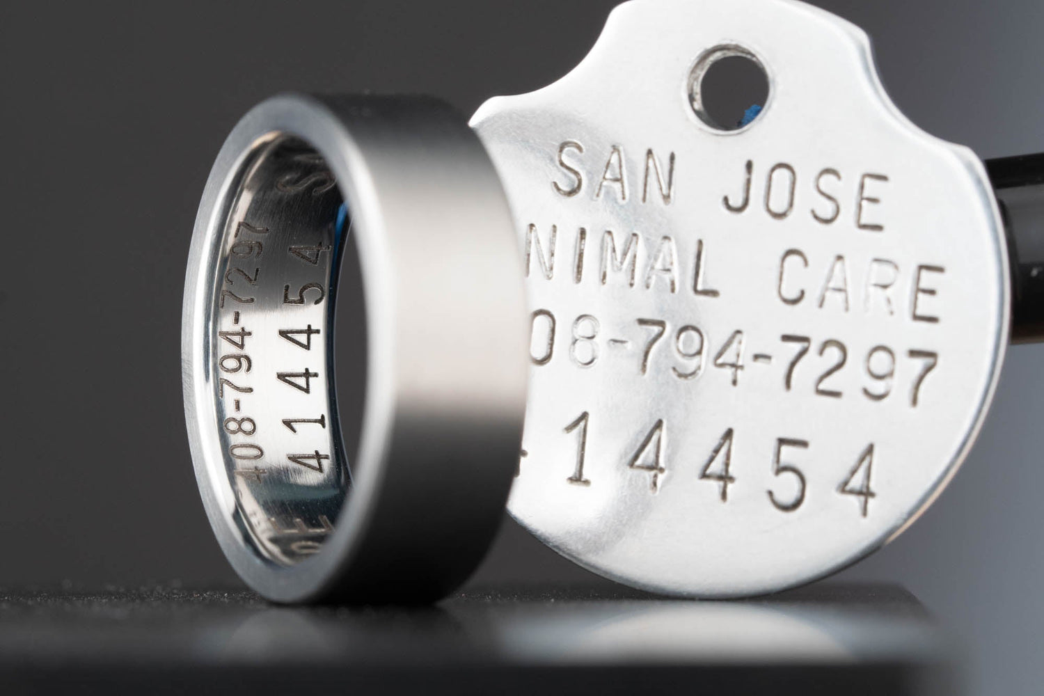 Detail shot of the engraved titanium ring and original stainless steel dog tag