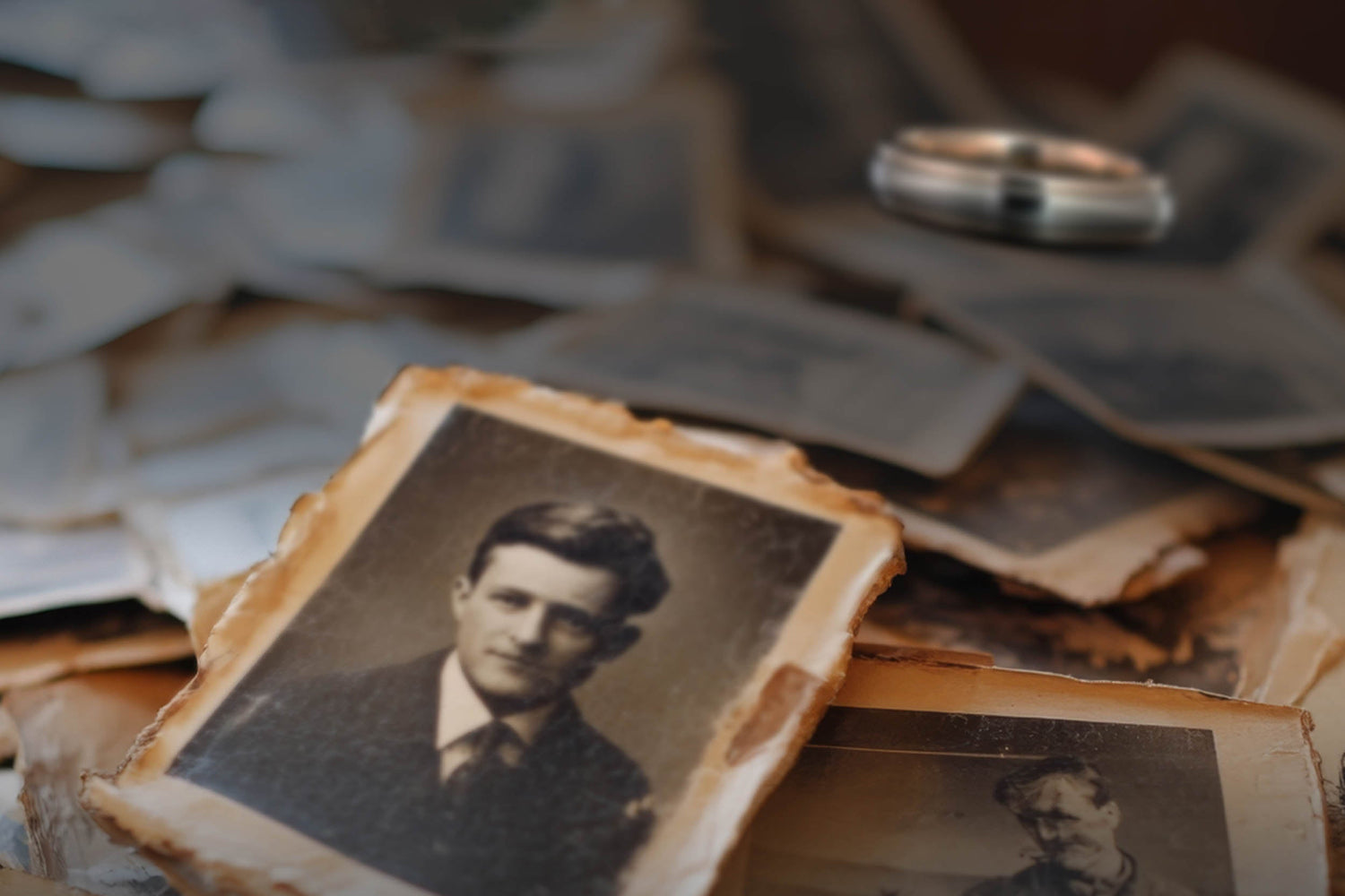 Vintage family photographs with a custom recreated wedding ring in the background. A lost heirloom ring restored by Honest Hands Ring Co. to honor family history.