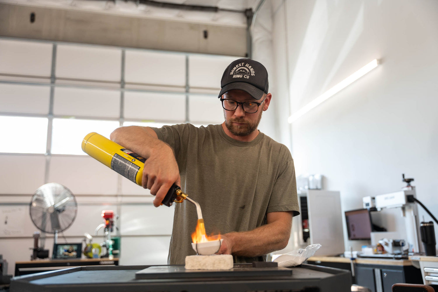 Craftsman at Honest Hands melting a 14k gold heirloom ring with a torch to begin the custom wedding band process.