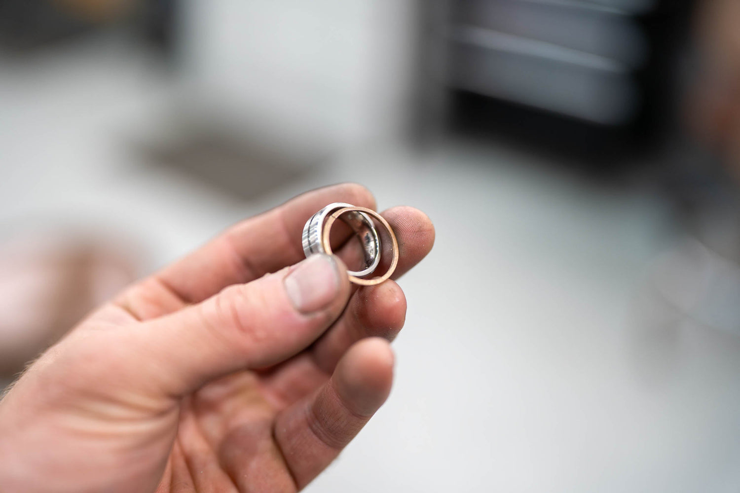 Stacked view of handmade wedding rings with split inlay design, combining crushed stone and wine barrel oak in gold and titanium bands.
