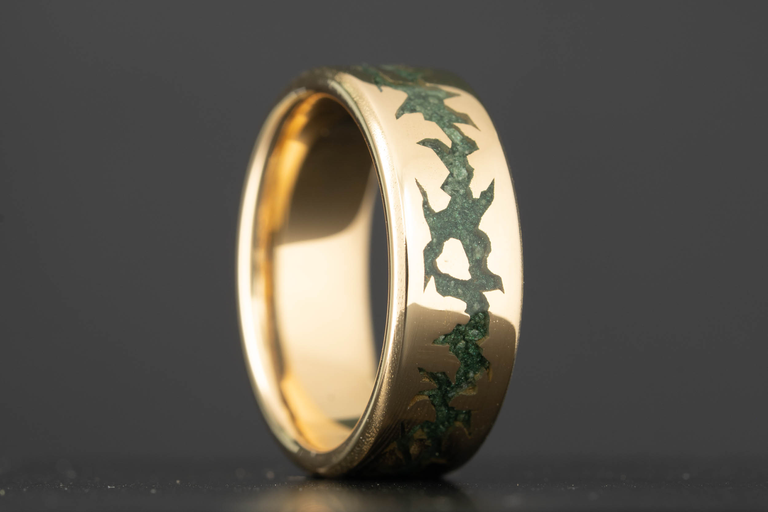 Custom 18k yellow gold wedding band with fractured moss agate inlay, showing jagged green stone channels running through polished gold, handcrafted in Colorado by Honest Hands Ring Co.