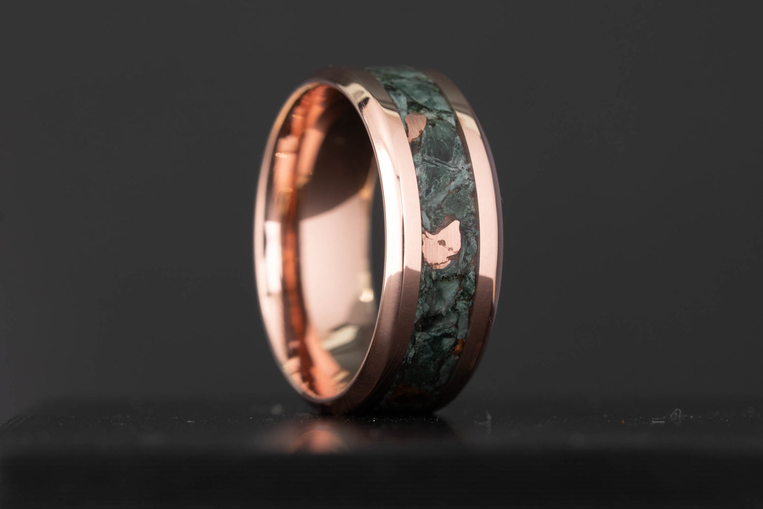 Tellurium copper wedding band with a crushed Keweenaw copper and Isle Royale greenstone inlay, showing bare copper flecks through the dark green stone, handcrafted by Honest Hands in Morrison, Colorado.